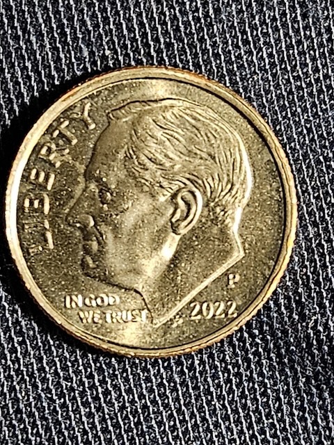 2022 dime off-center strike error showing blank crescent of planchet on one edge